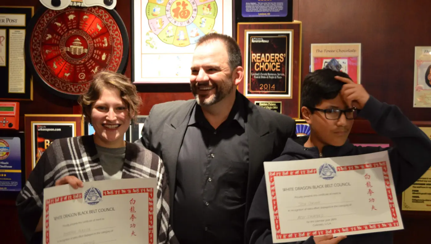 Sifu Post with two students holding up awards