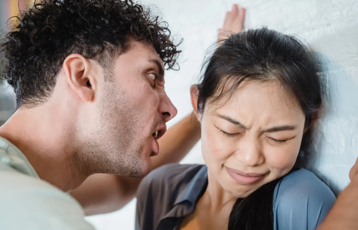 An aggressive man shouting at a fearful woman