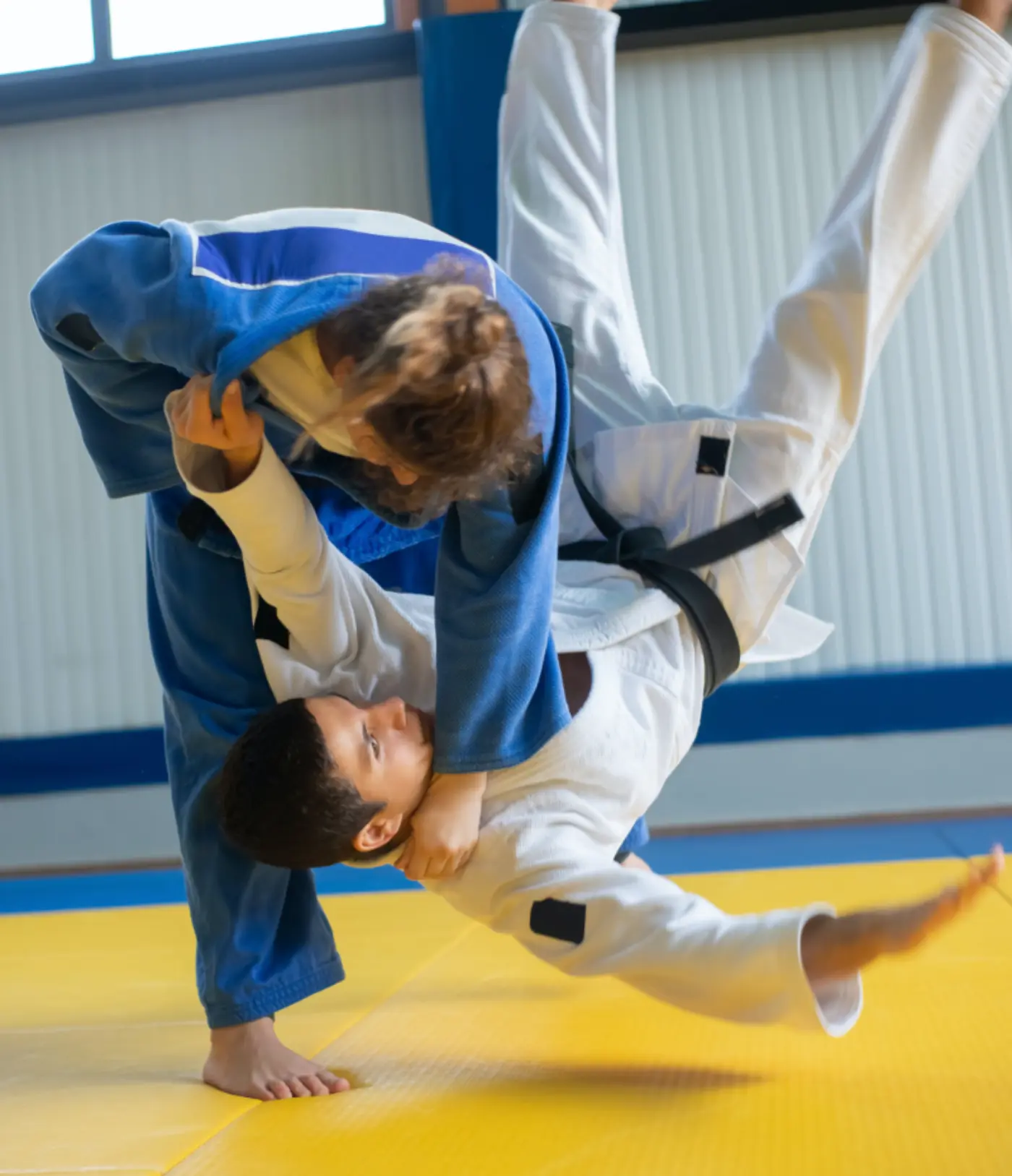 Two karate students practicing a leg throw